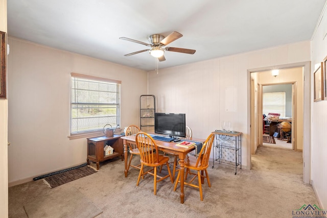 carpeted home office featuring a ceiling fan