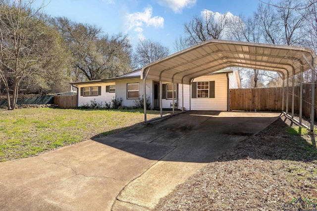 view of front of property featuring a carport, a front lawn, concrete driveway, and fence