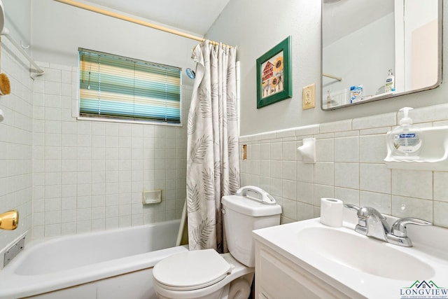 full bath featuring toilet, a wainscoted wall, shower / bathtub combination with curtain, vanity, and tile walls