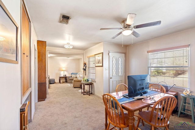 dining space with light carpet, ceiling fan, and visible vents