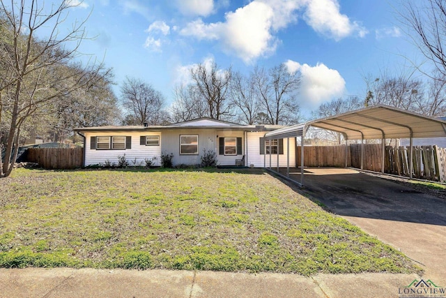 single story home featuring driveway, a front lawn, fence, and a detached carport