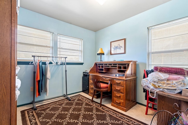 office area featuring light carpet and baseboards