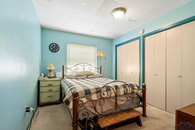 bedroom with light carpet and multiple closets