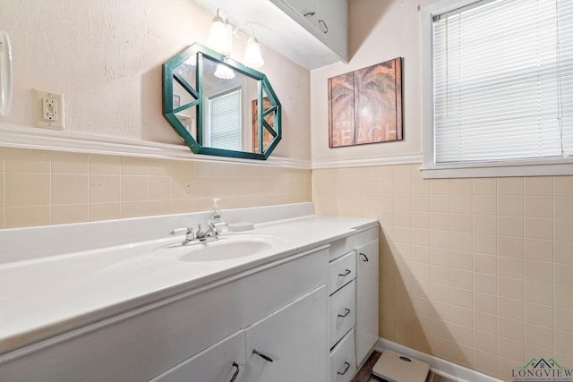 bathroom with wainscoting, tile walls, and vanity