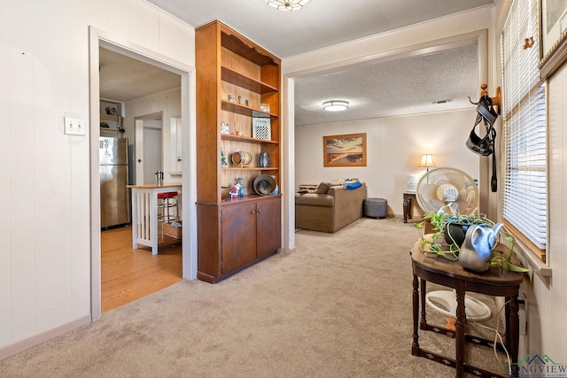 hall with carpet and a textured ceiling