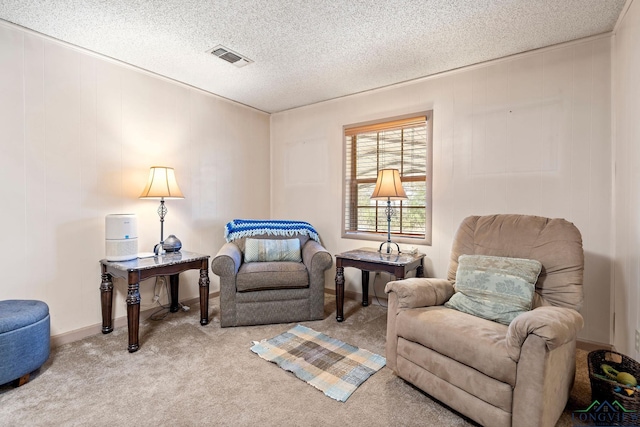 sitting room featuring a textured ceiling, carpet flooring, visible vents, and baseboards