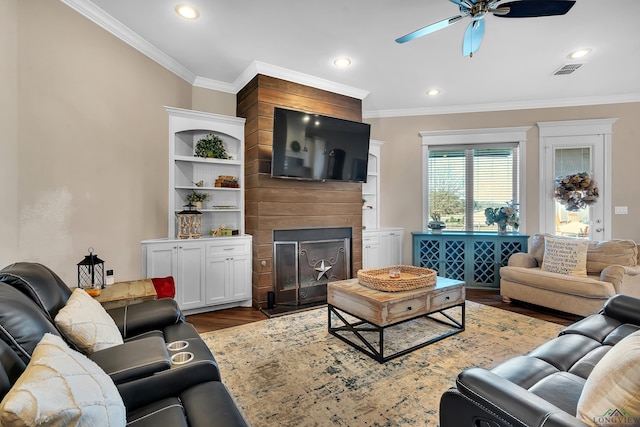 living room with dark hardwood / wood-style flooring, ornamental molding, and a fireplace