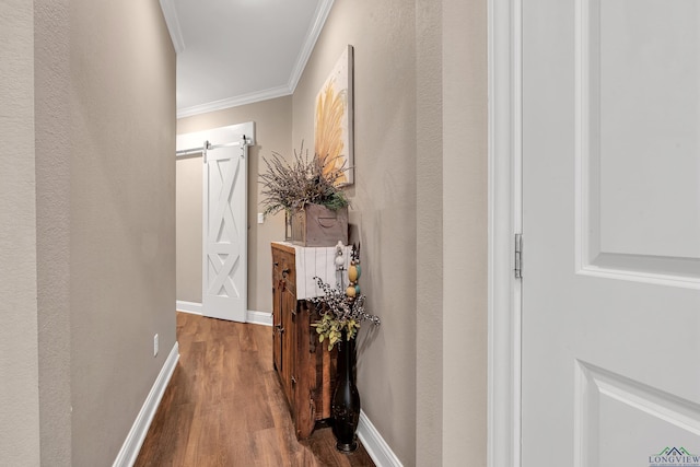 corridor featuring wood-type flooring, a barn door, and crown molding