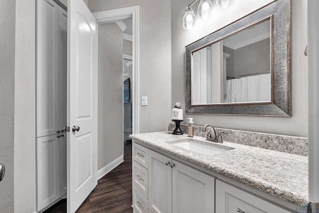 bathroom featuring vanity, hardwood / wood-style flooring, and ornamental molding