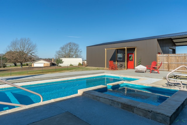 view of swimming pool with an outdoor structure, an in ground hot tub, and a patio