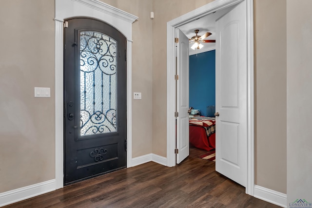 foyer entrance with ceiling fan and dark wood-type flooring