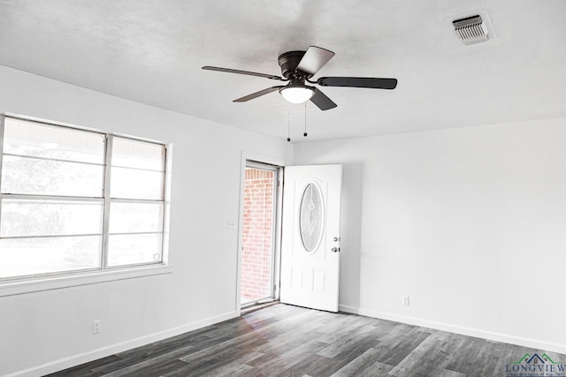 unfurnished room featuring dark wood-type flooring and ceiling fan