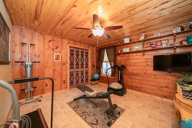 workout area featuring wooden ceiling, ceiling fan, and wooden walls