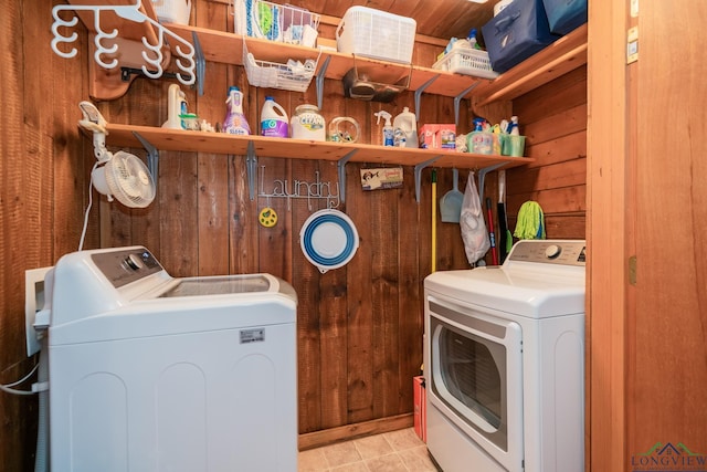 laundry room featuring washing machine and dryer and wood walls