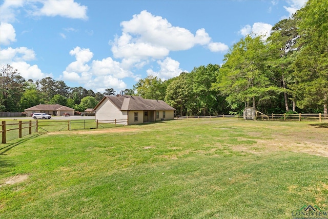 view of yard with an outdoor structure, a storage unit, and a fenced backyard