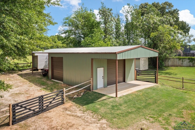 view of outdoor structure featuring fence and an outbuilding