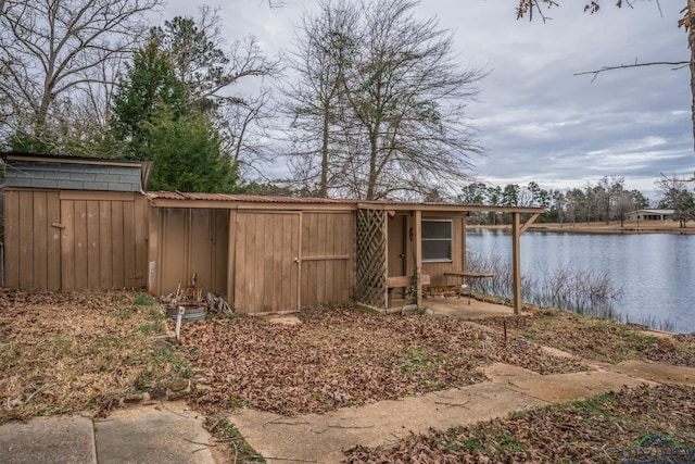 view of yard with a water view, a shed, and an outdoor structure