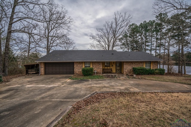 view of front of home with driveway, brick siding, roof with shingles, and an attached garage