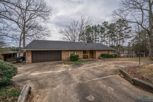 view of front of house featuring driveway, a garage, and brick siding