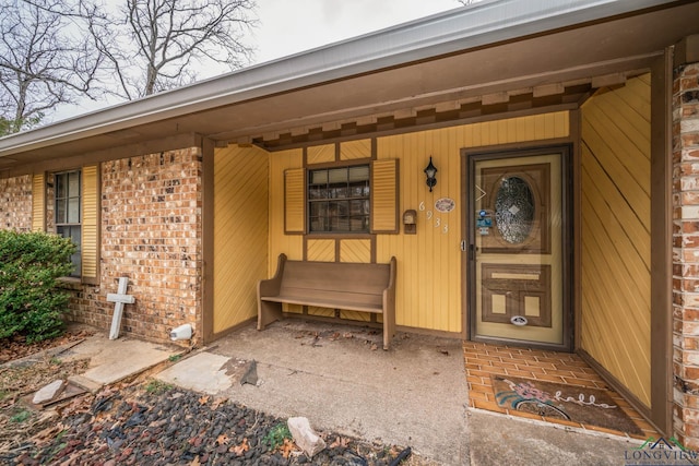 doorway to property with brick siding