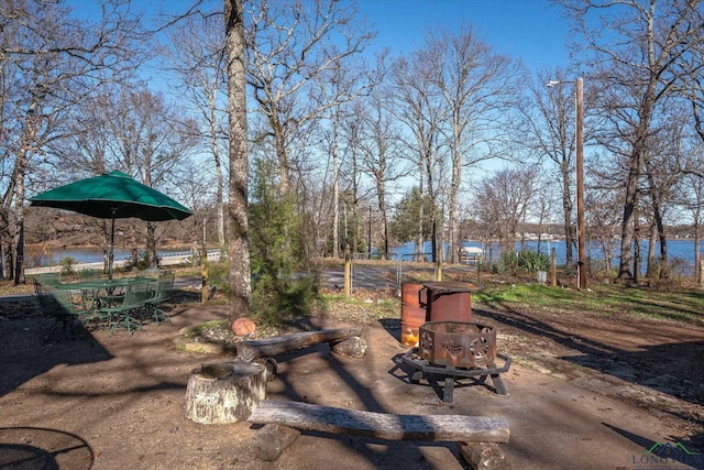 view of yard featuring a water view and an outdoor fire pit