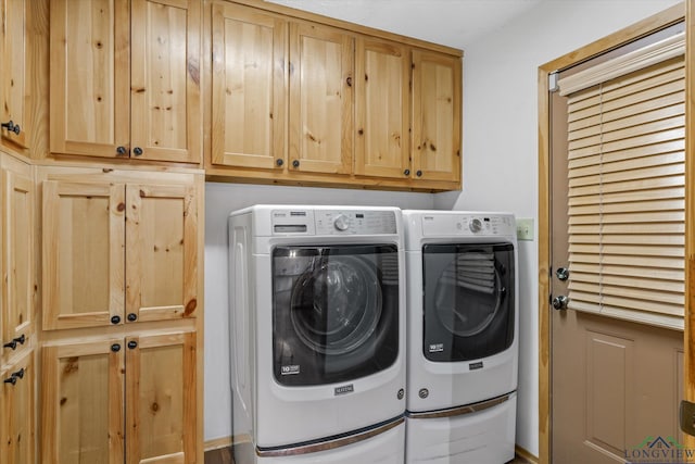 laundry area featuring washing machine and dryer and cabinets