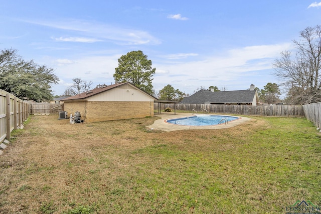 view of yard featuring a fenced in pool and central AC