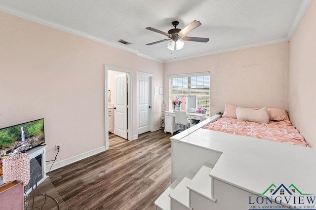 bedroom featuring baseboards, dark wood-type flooring, visible vents, and crown molding