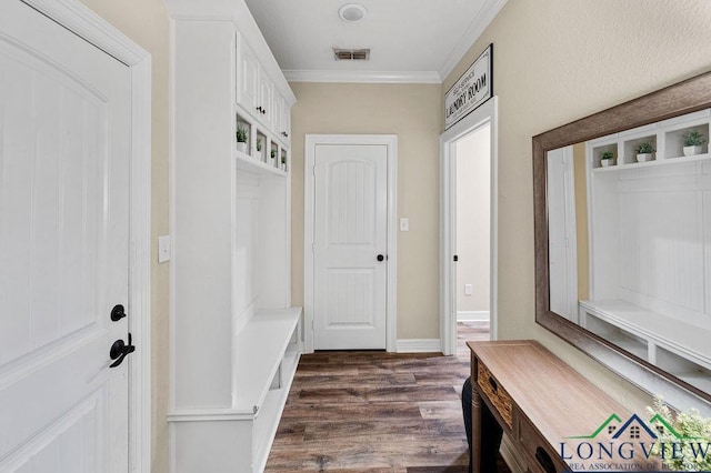 mudroom featuring ornamental molding, visible vents, dark wood finished floors, and baseboards