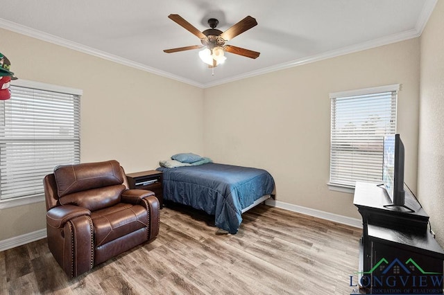 bedroom featuring ornamental molding, multiple windows, wood finished floors, and baseboards