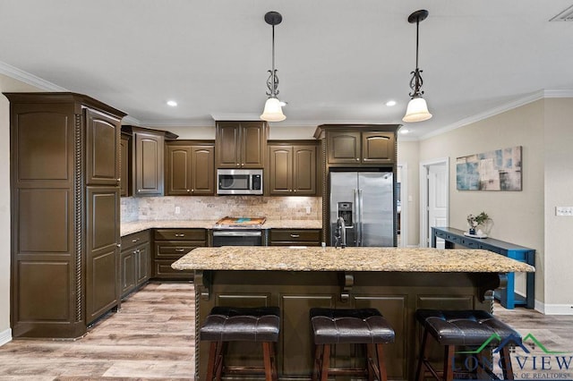 kitchen featuring stainless steel appliances, dark brown cabinets, and a kitchen island with sink