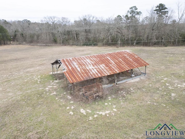 view of home's community featuring a wooded view, a lawn, and an outbuilding