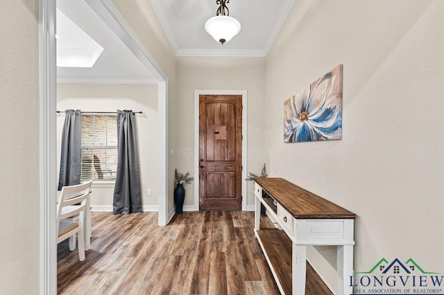 foyer entrance with baseboards, ornamental molding, and wood finished floors