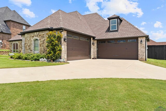 1600 Olympic Dr, Longview, TX 75605 - view of front of home with a garage, a front yard, driveway, brick siding, and a shingled roof