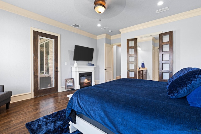 1600 Olympic Dr, Longview, TX 75605 - bedroom featuring wood finished floors, crown molding, a glass covered fireplace, baseboards, and ceiling fan