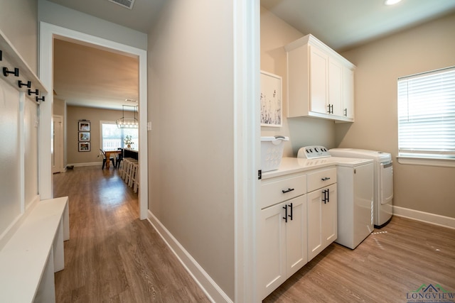 laundry area with cabinets, independent washer and dryer, and light wood-type flooring