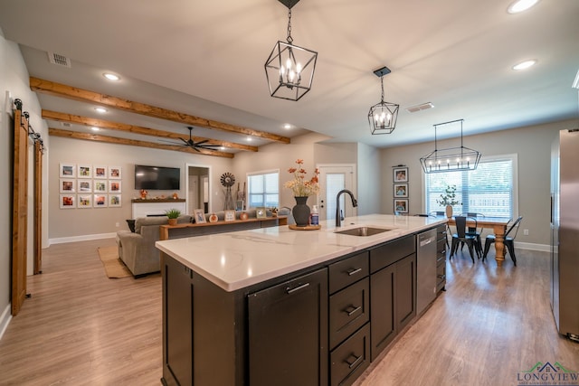 kitchen with a kitchen island with sink, sink, hanging light fixtures, ceiling fan, and beamed ceiling