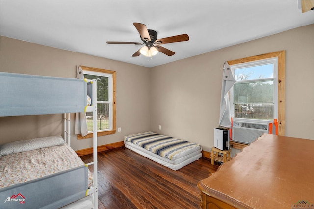 bedroom featuring cooling unit, ceiling fan, dark hardwood / wood-style flooring, and multiple windows