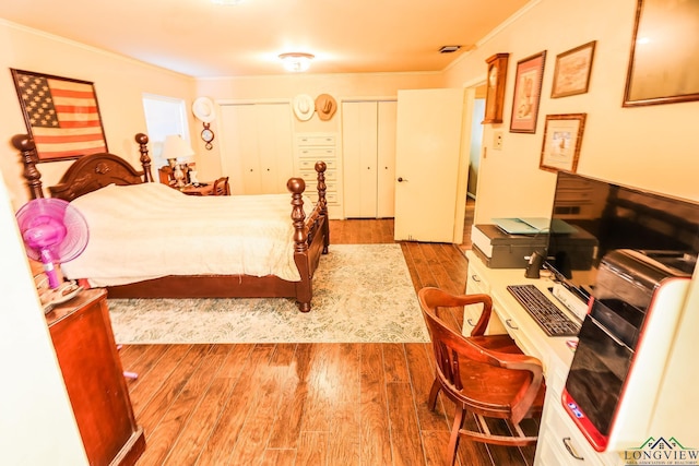 bedroom featuring wood-type flooring and crown molding