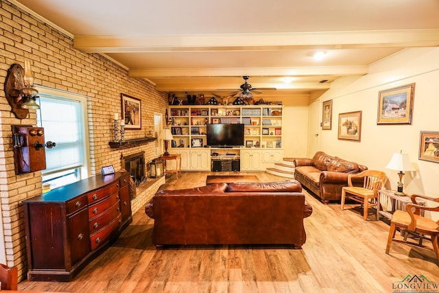 living room featuring ceiling fan, beam ceiling, a fireplace, and brick wall