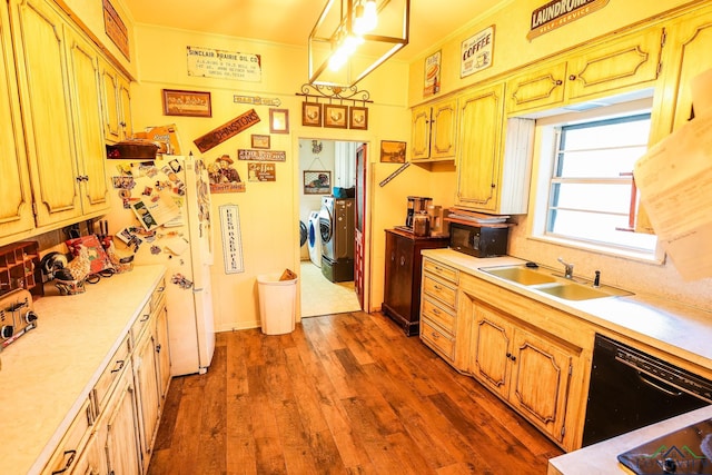 kitchen featuring dishwasher, sink, dark wood-type flooring, independent washer and dryer, and decorative light fixtures