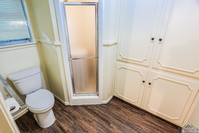 bathroom featuring hardwood / wood-style flooring, toilet, and walk in shower