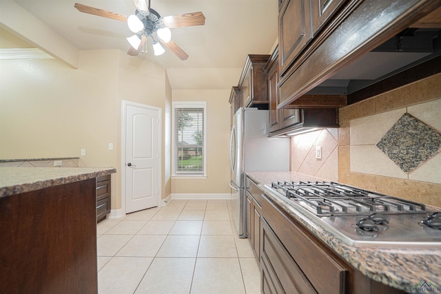2532 Windmill Ln, Longview, TX 75601 - kitchen with stainless steel gas cooktop, custom exhaust hood, decorative backsplash, dark brown cabinetry, and ceiling fan