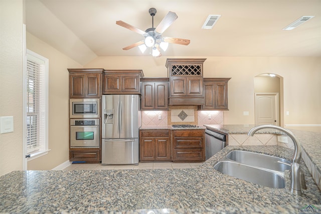 2532 Windmill Ln, Longview, TX 75601 - kitchen featuring stainless steel appliances, backsplash, ceiling fan, light tile patterned flooring, and arched walkways