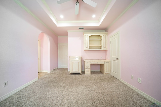 unfurnished living room with arched walkways, crown molding, a raised ceiling, light colored carpet, and baseboards