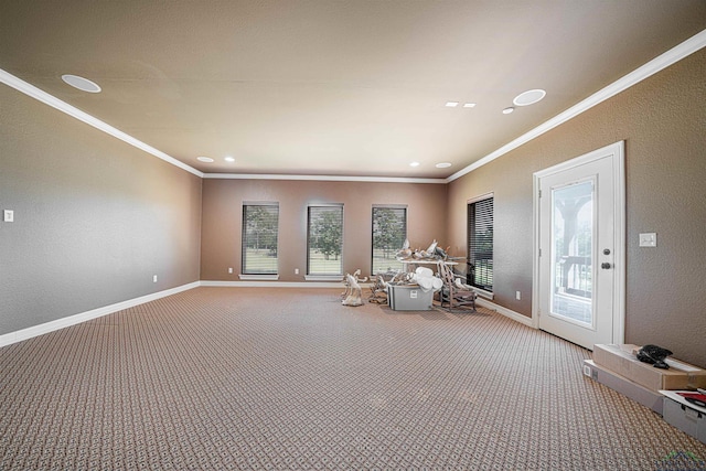 interior space featuring crown molding, carpet floors, baseboards, and a healthy amount of sunlight