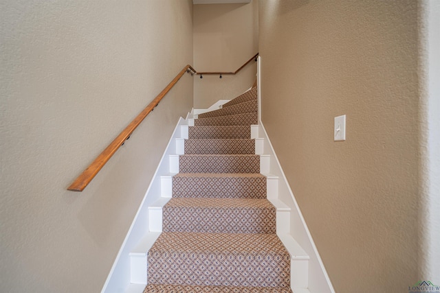 staircase featuring tile patterned flooring and a textured wall