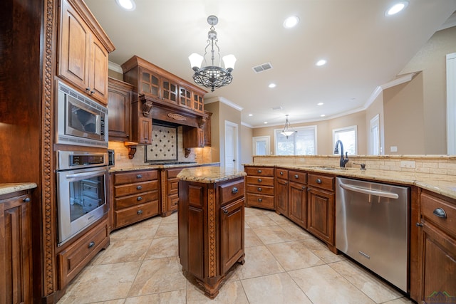 kitchen featuring stainless steel appliances, a sink, visible vents, hanging light fixtures, and decorative backsplash