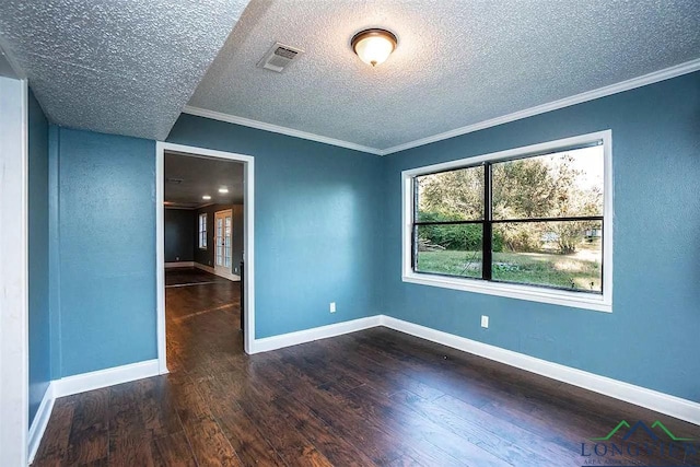spare room featuring crown molding, wood finished floors, a textured ceiling, baseboards, and visible vents