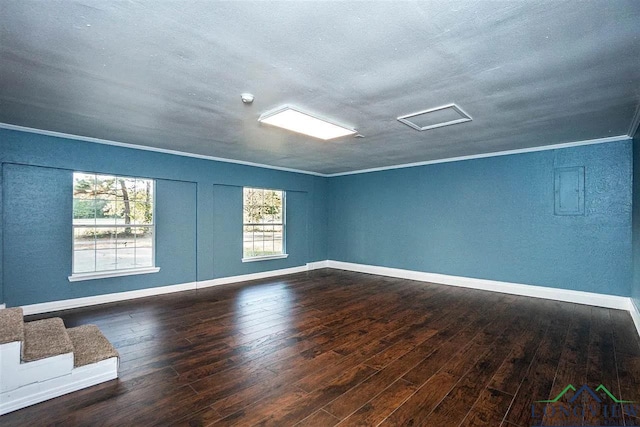 empty room featuring baseboards, a textured ceiling, ornamental molding, and hardwood / wood-style flooring
